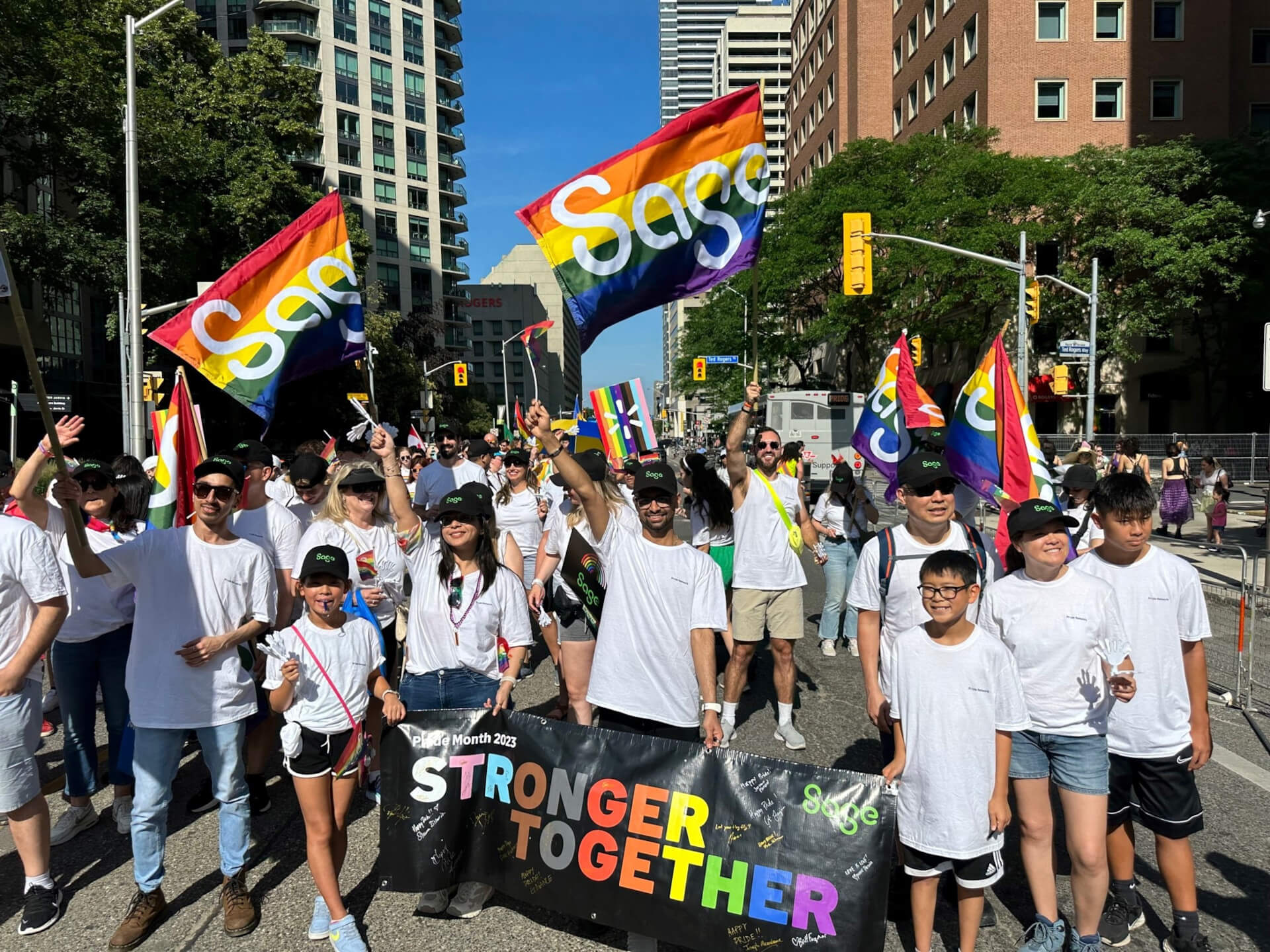   Equal opportunity - photo of Sage colleagues at a Pride march with banner: Stronger Together