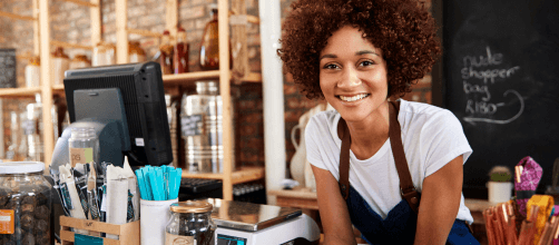 Smiling young woman small business owner in her shop